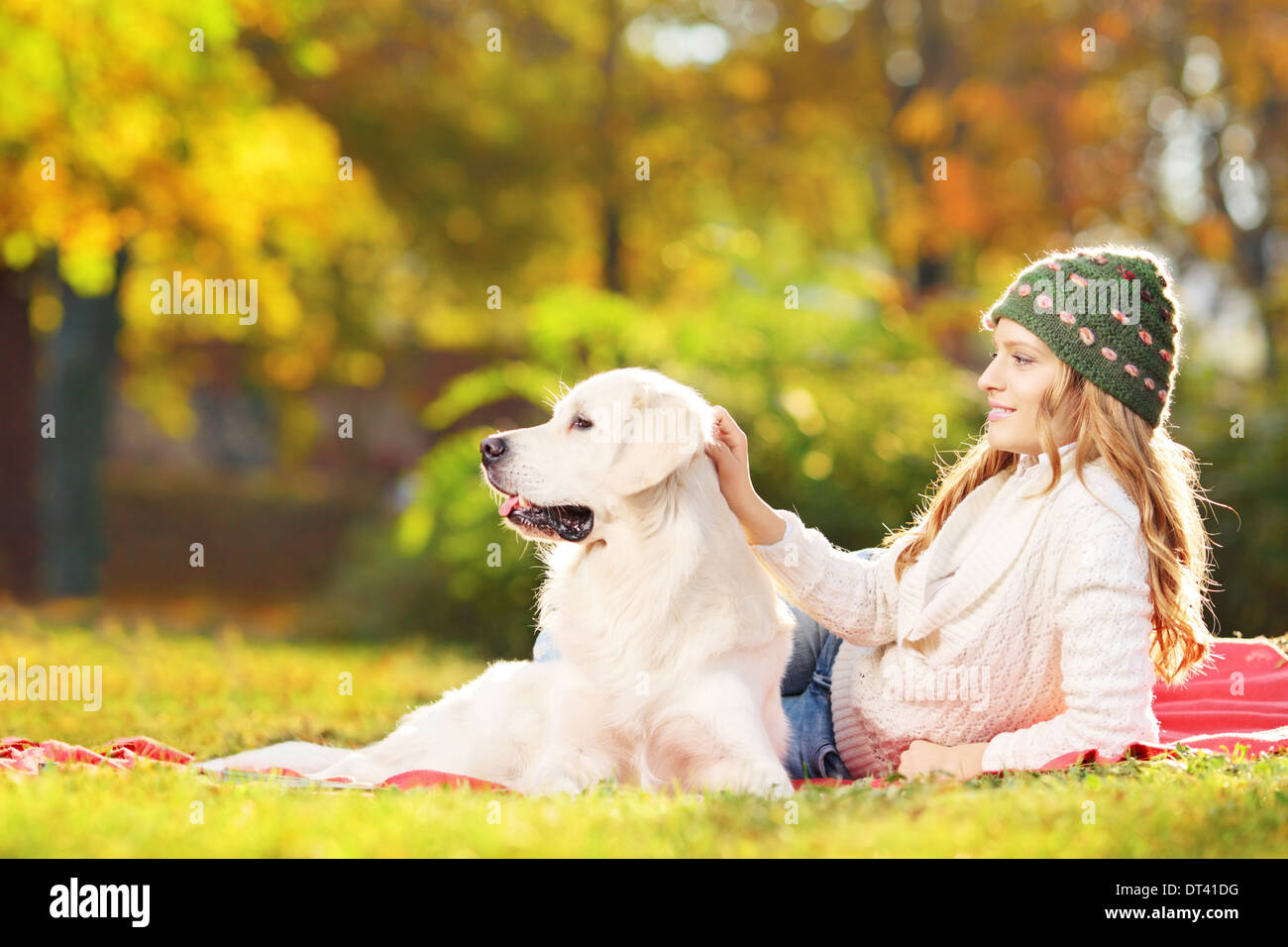 Femmina giacente su erba con il suo labrador retriever cane in un parco Foto Stock