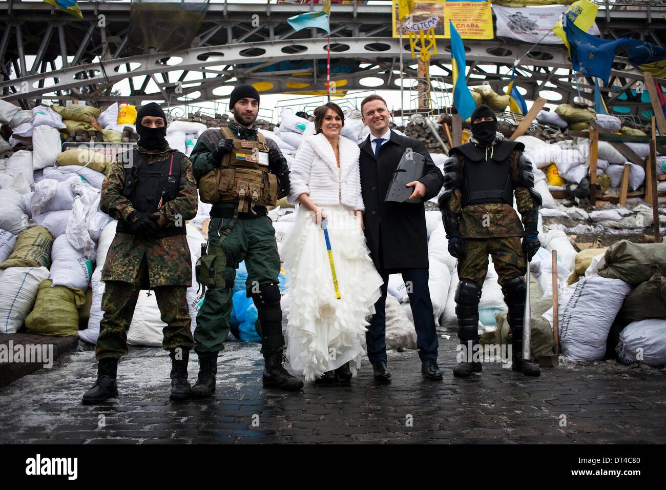 Kiev, Ucraina. 8 Feb 2014. Una coppia di novelli sposi bacio sulla piazza Indipendenza di fronte le barricate come opposizione manifestanti continuano ad occupare Kiev piazza centrale in data 8 febbraio 2014. Il Euromaidan è un'onda di continue dimostrazioni e disordini civili in Ucraina, che ha avuto inizio nella notte del 21 novembre 2013 con proteste pubbliche chiedono una più stretta integrazione europea. La portata delle proteste ha evoluto con molte chiamate per le dimissioni del Presidente Viktor Yanukovych e il suo governo e la volontà di cambiare la vita in Ucraina. Foto di Emerico Fohlen/NurPhoto (credito Immagine: © Emeri Foto Stock