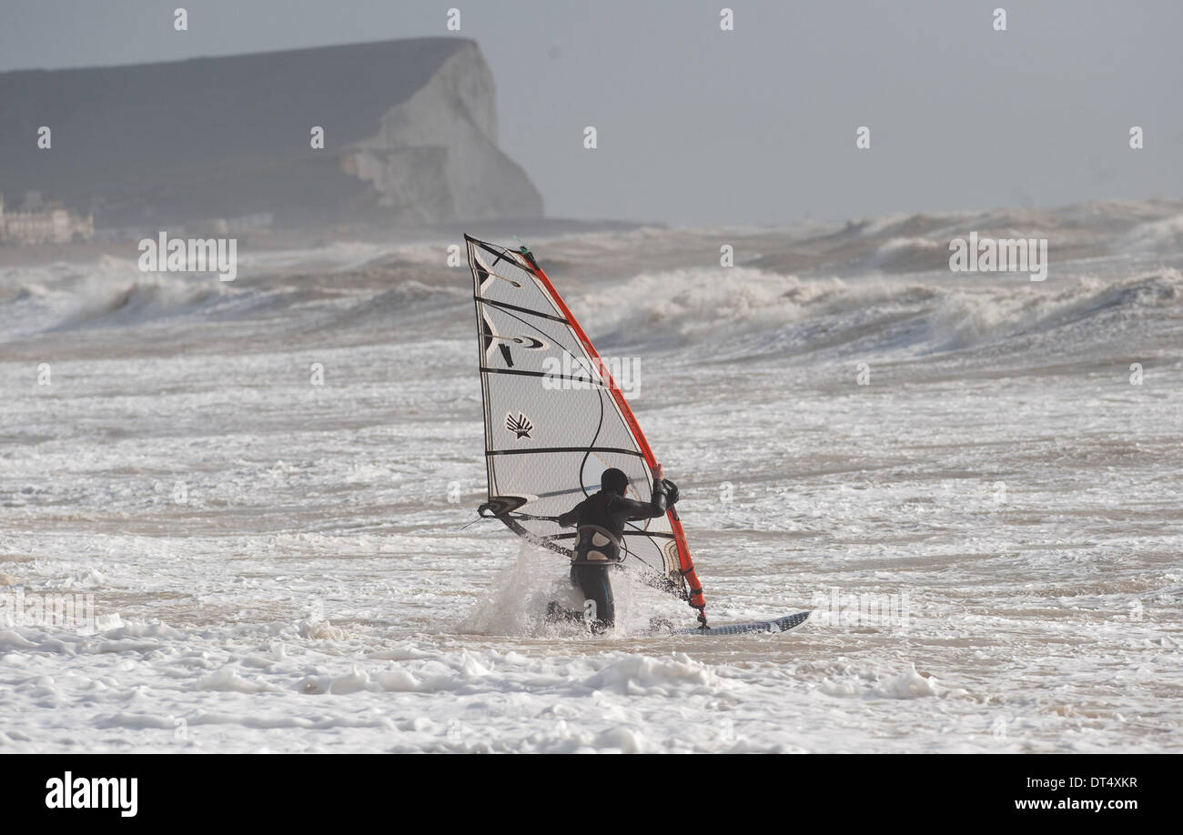 Un windsurf battaglie contro le onde a Newhaven oggi come tempeste continuare a pastella costa meridionale della Gran Bretagna Foto Stock
