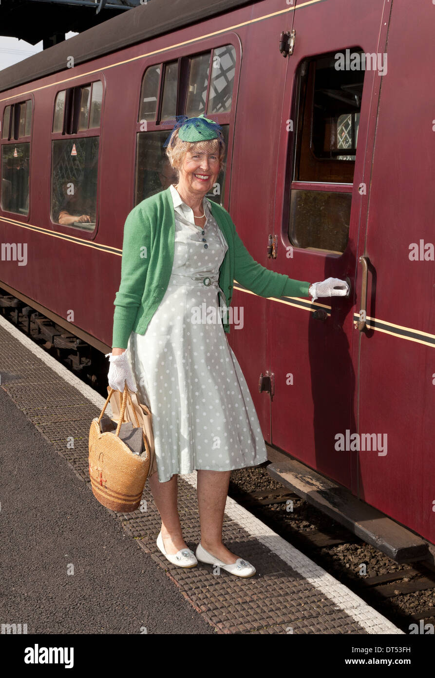 Una donna di salire a bordo di un treno che indossa1940's costume Foto Stock