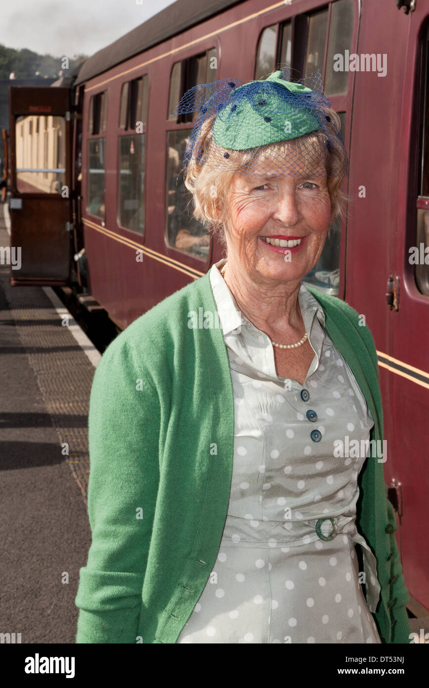 Una donna di salire a bordo di un treno vestito in 1940's costume Foto Stock