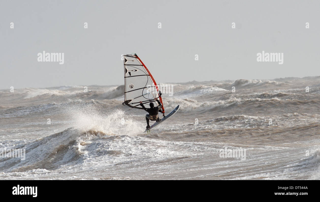 Un windsurf battaglie contro le onde off Tide Mills beach Newhaven oggi come tempeste continuare a pastella costa meridionale della Gran Bretagna Foto Stock