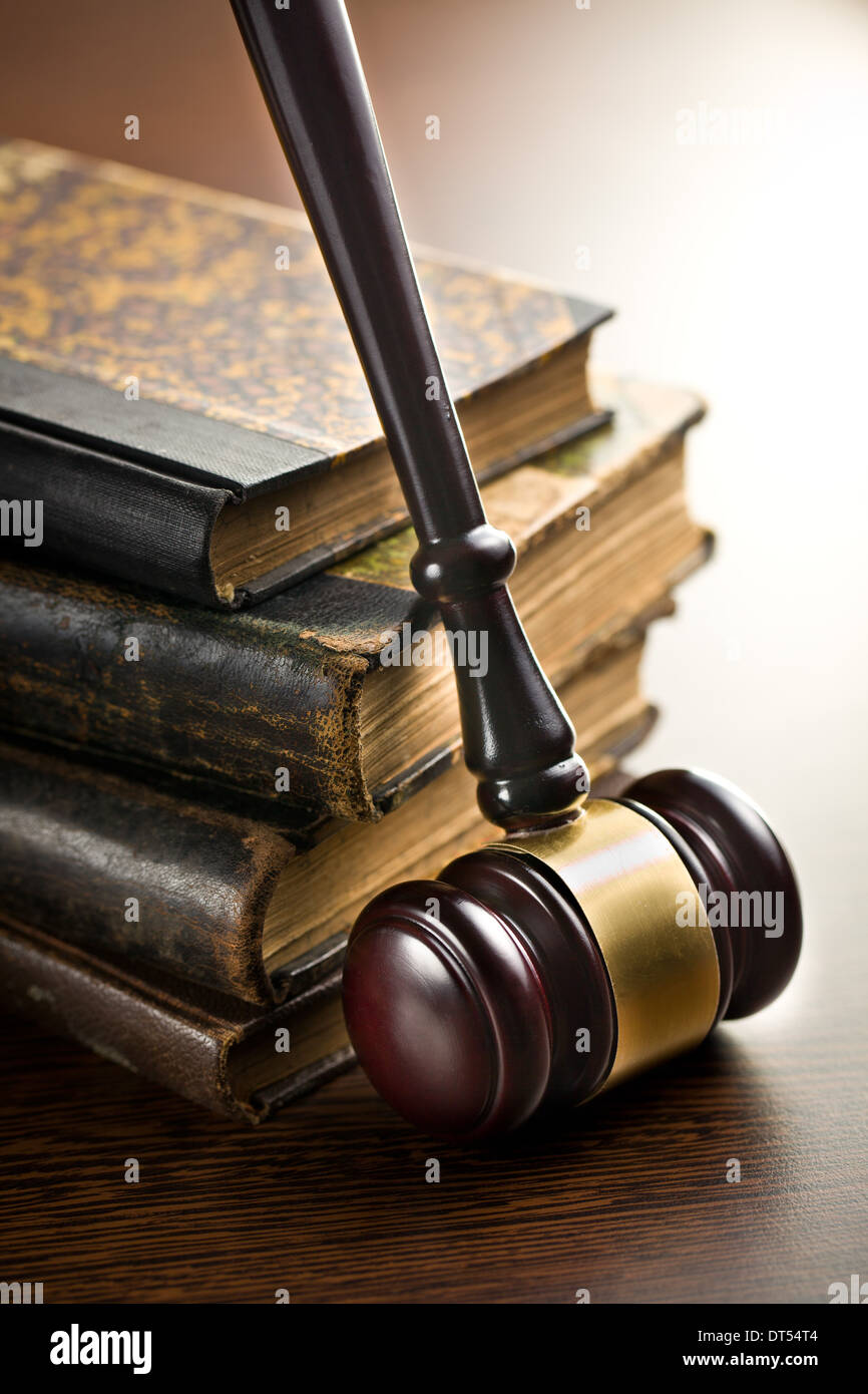 Giudice martello con vecchi libri sullo sfondo di legno Foto Stock
