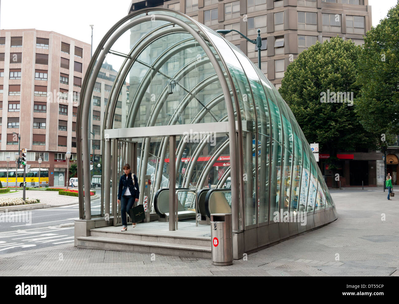 Una donna lascia a Bilbao la stazione della metropolitana di Bilbao, Spagna, attraverso un 'Fosterito' struttura in vetro in onore di Sir Norman Foster. Foto Stock