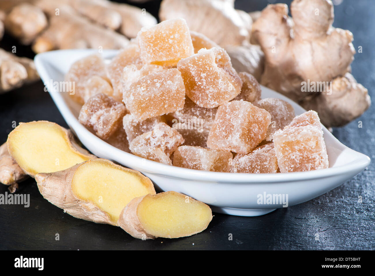 Dolce essiccato cubetti di zenzero su sfondo scuro Foto Stock
