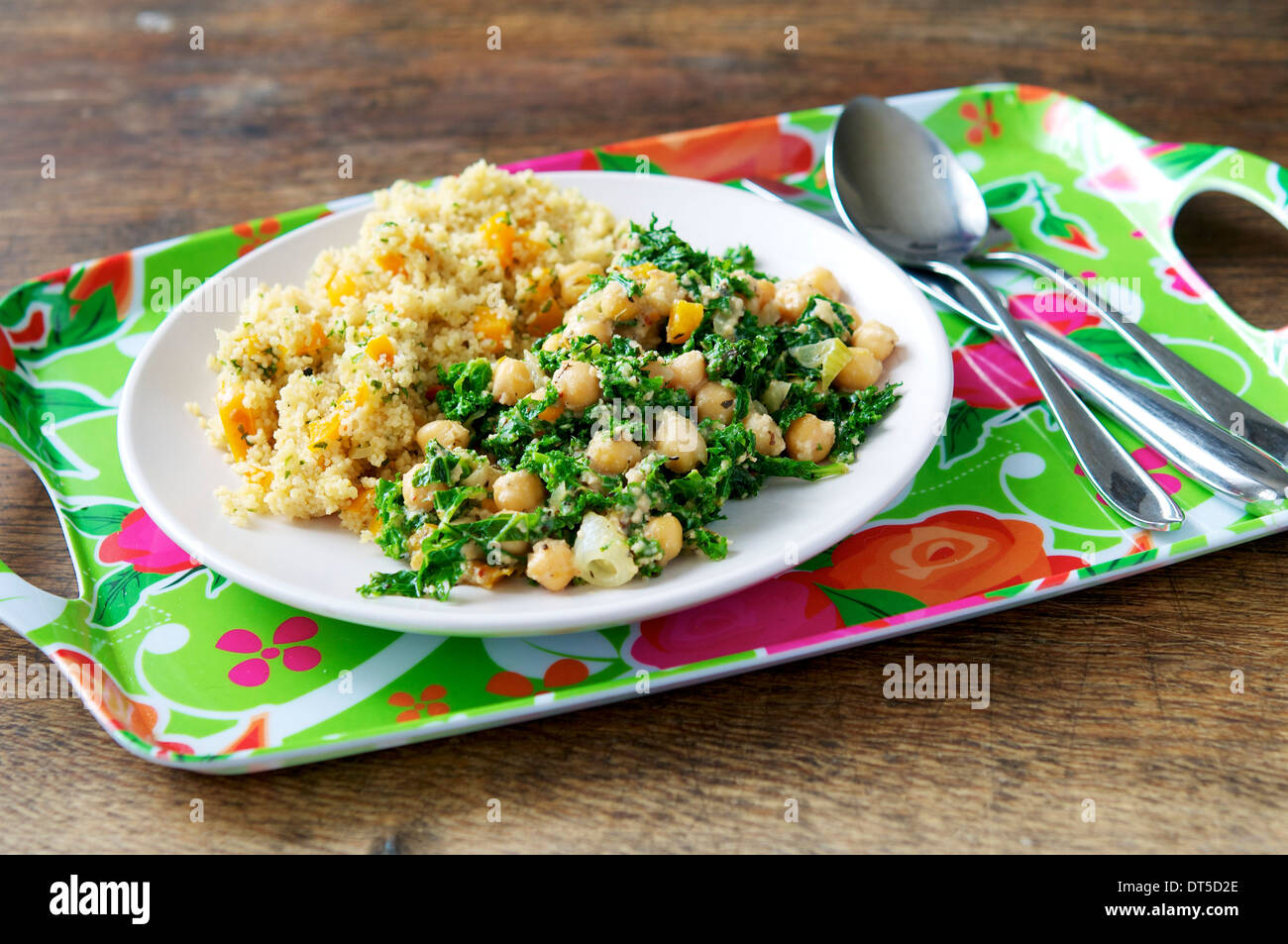 Una sostanziosa e pasto di riempimento con kale, anacardi e ceci, servita con i confetti cuscus. Foto Stock