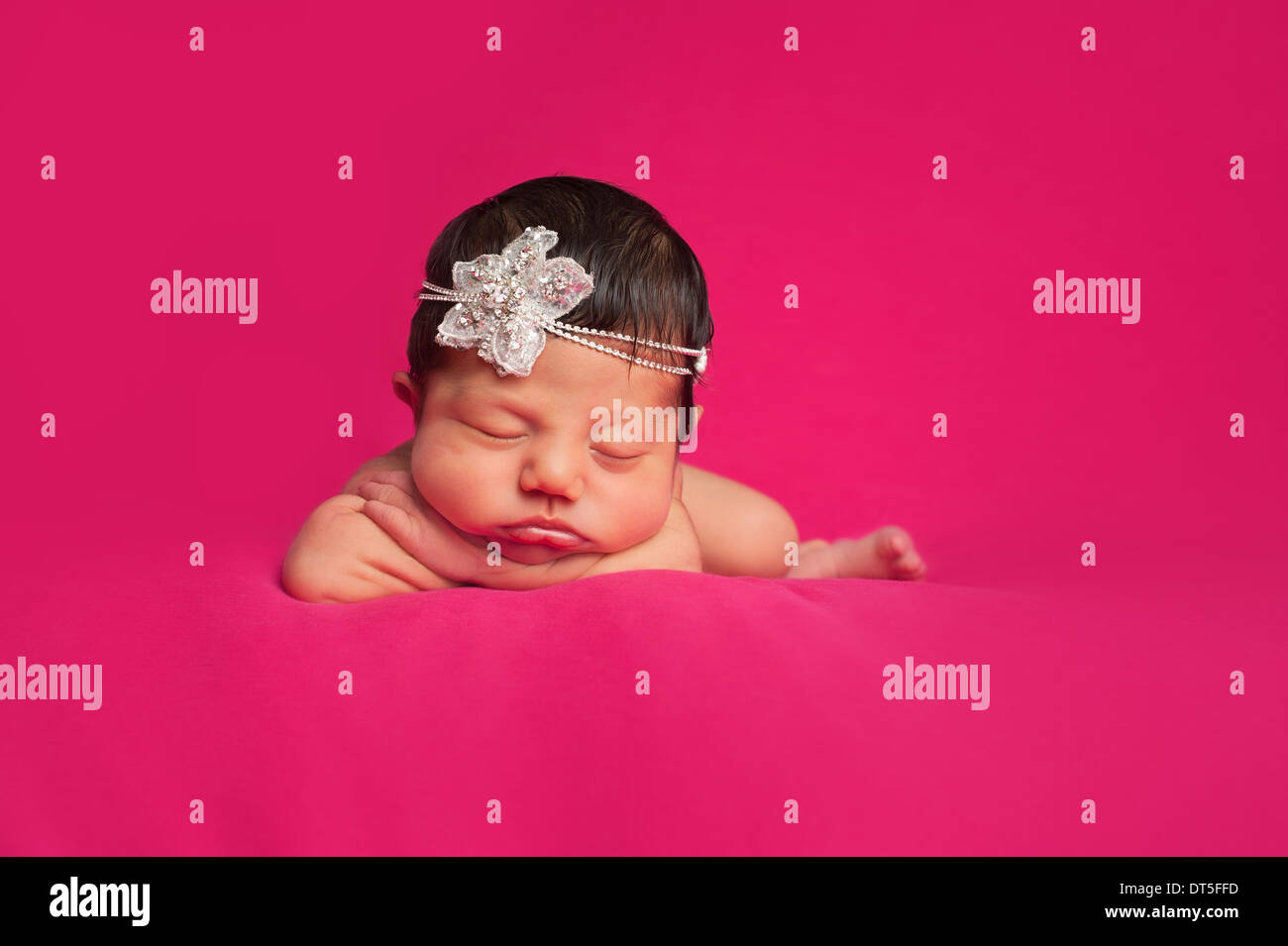 Un bel giorno 8 vecchia neonato bambina indossa una fantasia archetto di strass. Girato in studio su un caldo sfondo rosa. Foto Stock