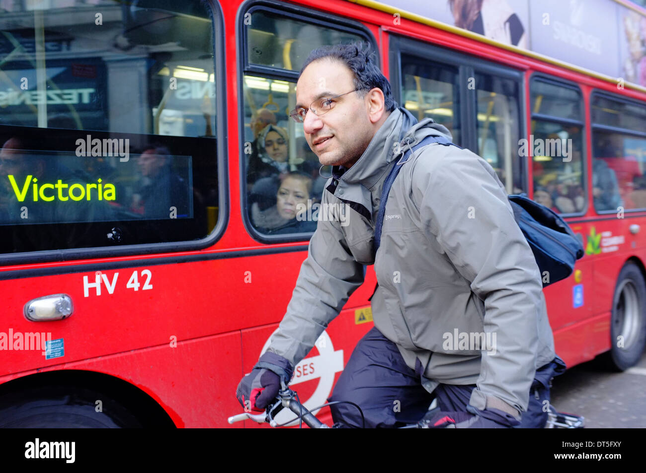 Ciclista con Red Bus londinese di Oxford Street, Londra Foto Stock