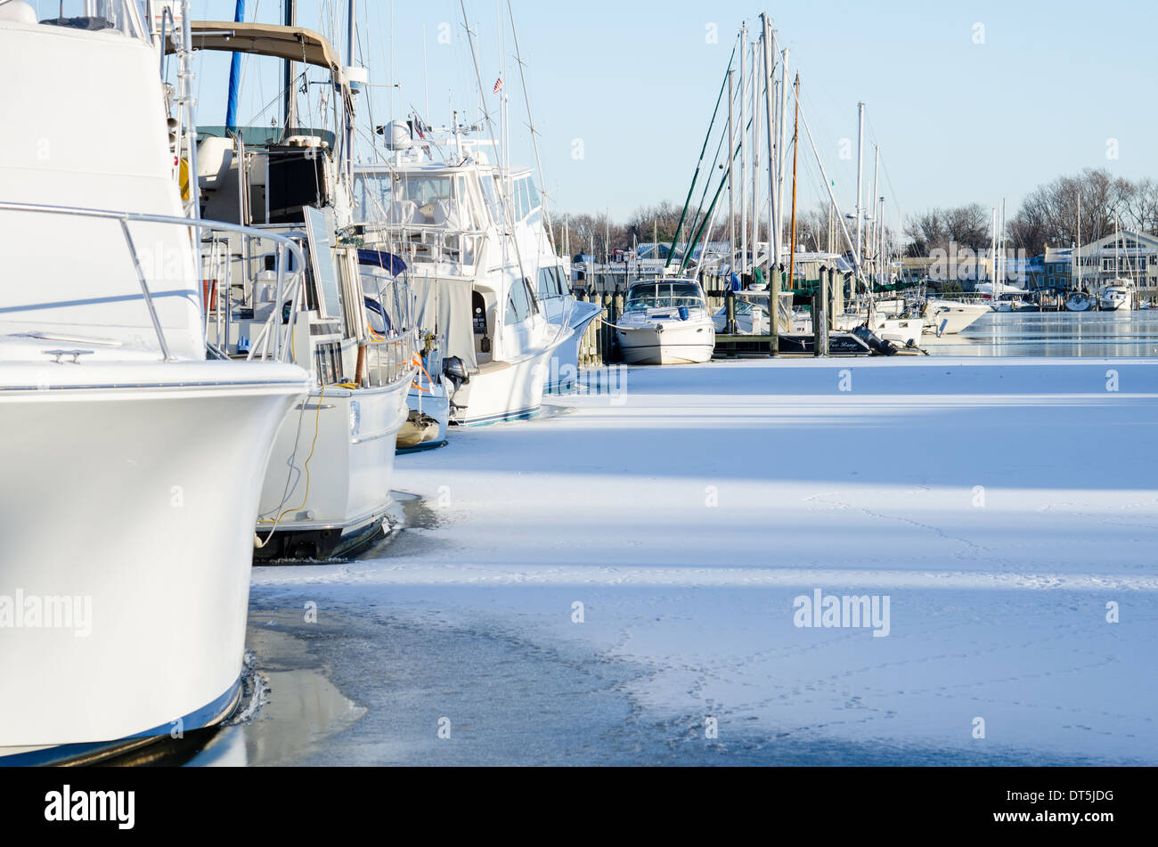 Motore e barche a vela congelati in come Annapolis Harbour ricoperto di ghiaccio. Foto Stock