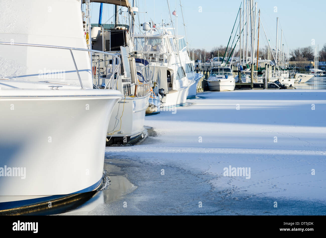 Motore e barche a vela congelati in come Annapolis Harbour ricoperto di ghiaccio. Foto Stock