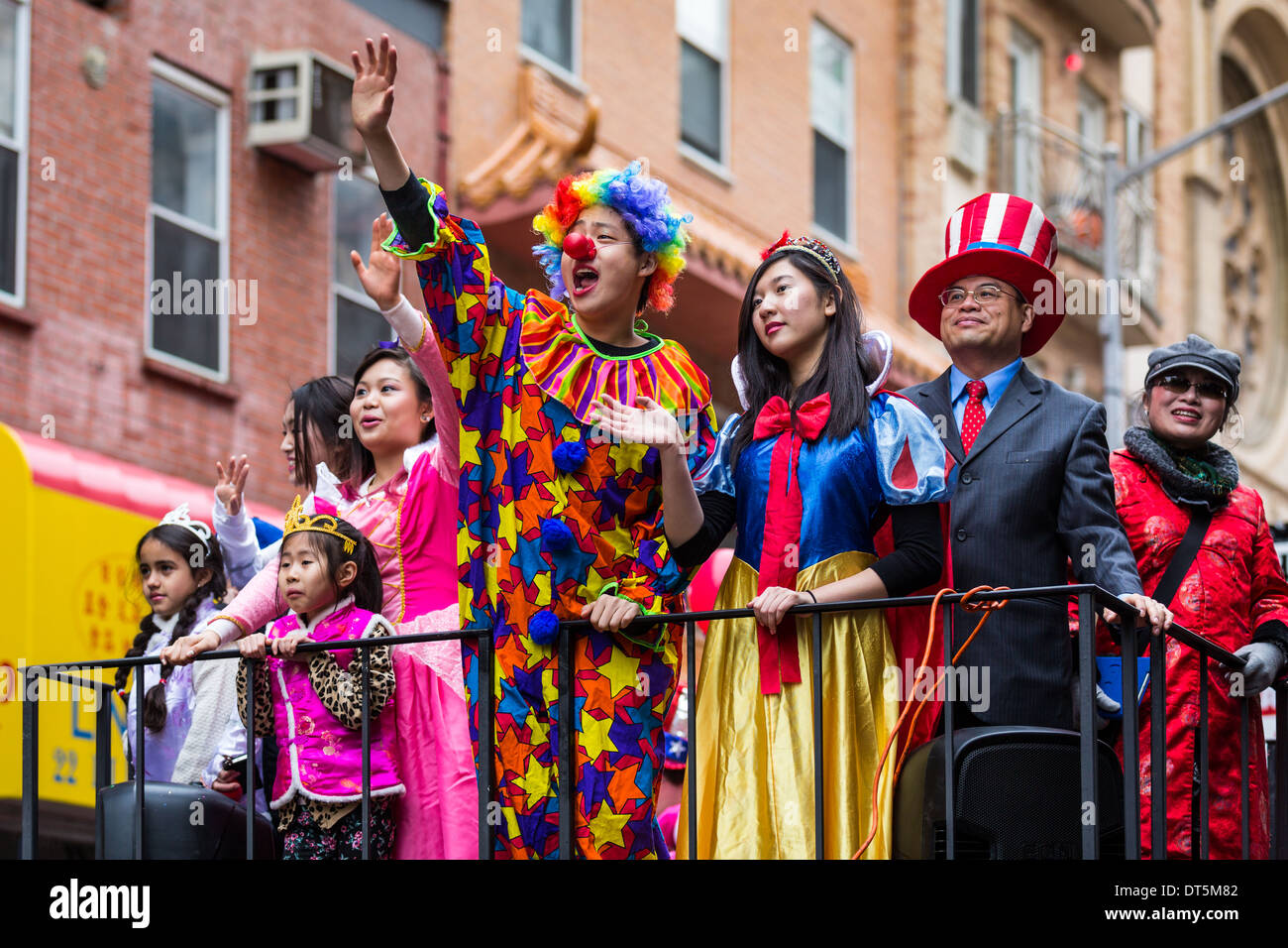 Giovane uomo vestito con un costume da clown saluta la folla presso il nuovo anno lunare Festival a Chinatown Foto Stock