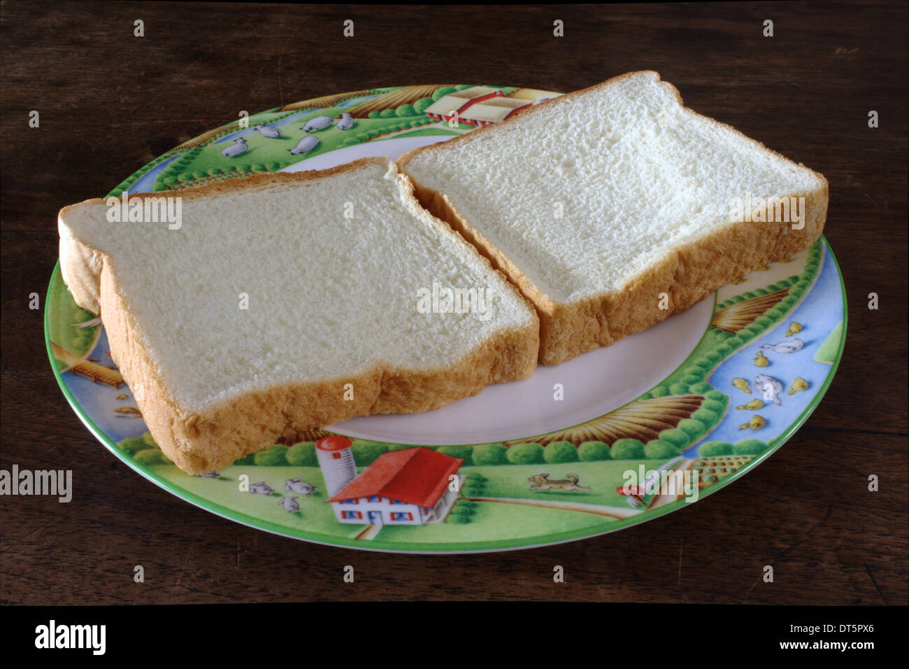 Due pezzi di pane, recante su di una piastra. Prima immagine di una serie sulla creazione di un burro di arachidi e gelatina sandwich. Foto Stock