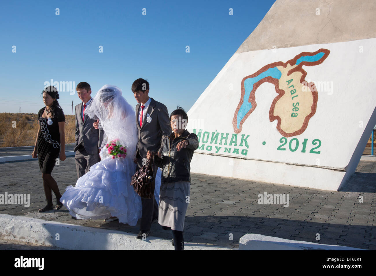 Un matrimonio uzbeko processione da un memoriale al lago Aral nell'ex porto di Moynaq, Uzbekistan. Foto Stock