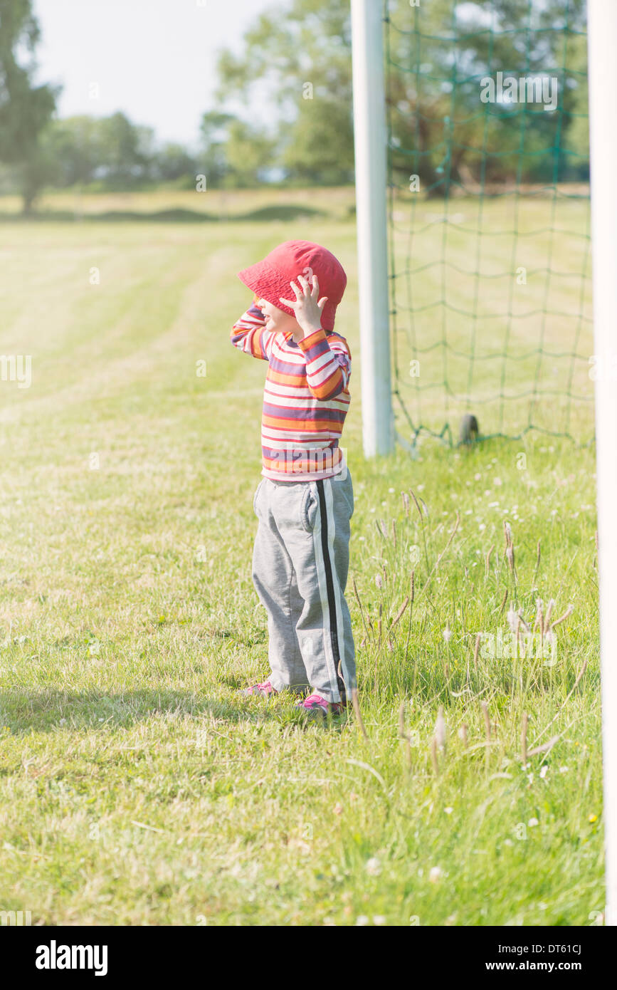 Giovane ragazza che gioca con la rete del gioco del calcio (calcio) obiettivo Foto Stock