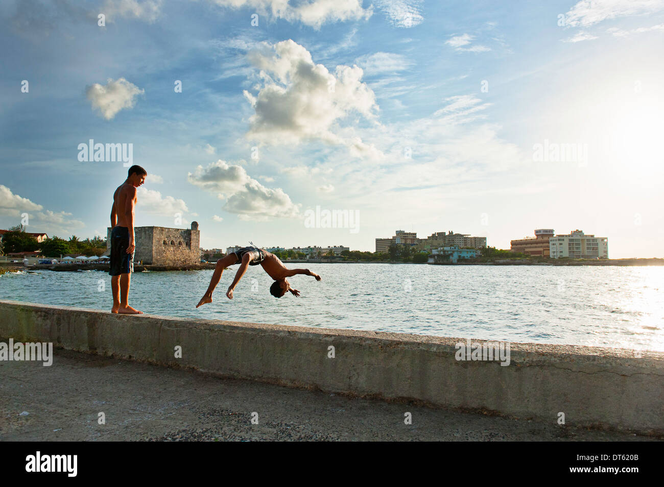 Due ragazzi giocare e immersioni dalla parete del porto, Havana, Cuba Foto Stock