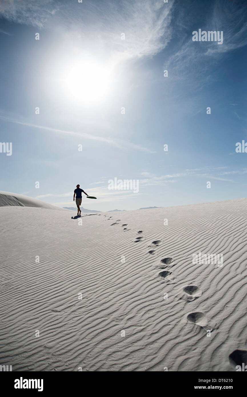 Giovane uomo che cammina attraverso dune di sabbia, sabbie bianche, Nuovo Messico, STATI UNITI D'AMERICA Foto Stock