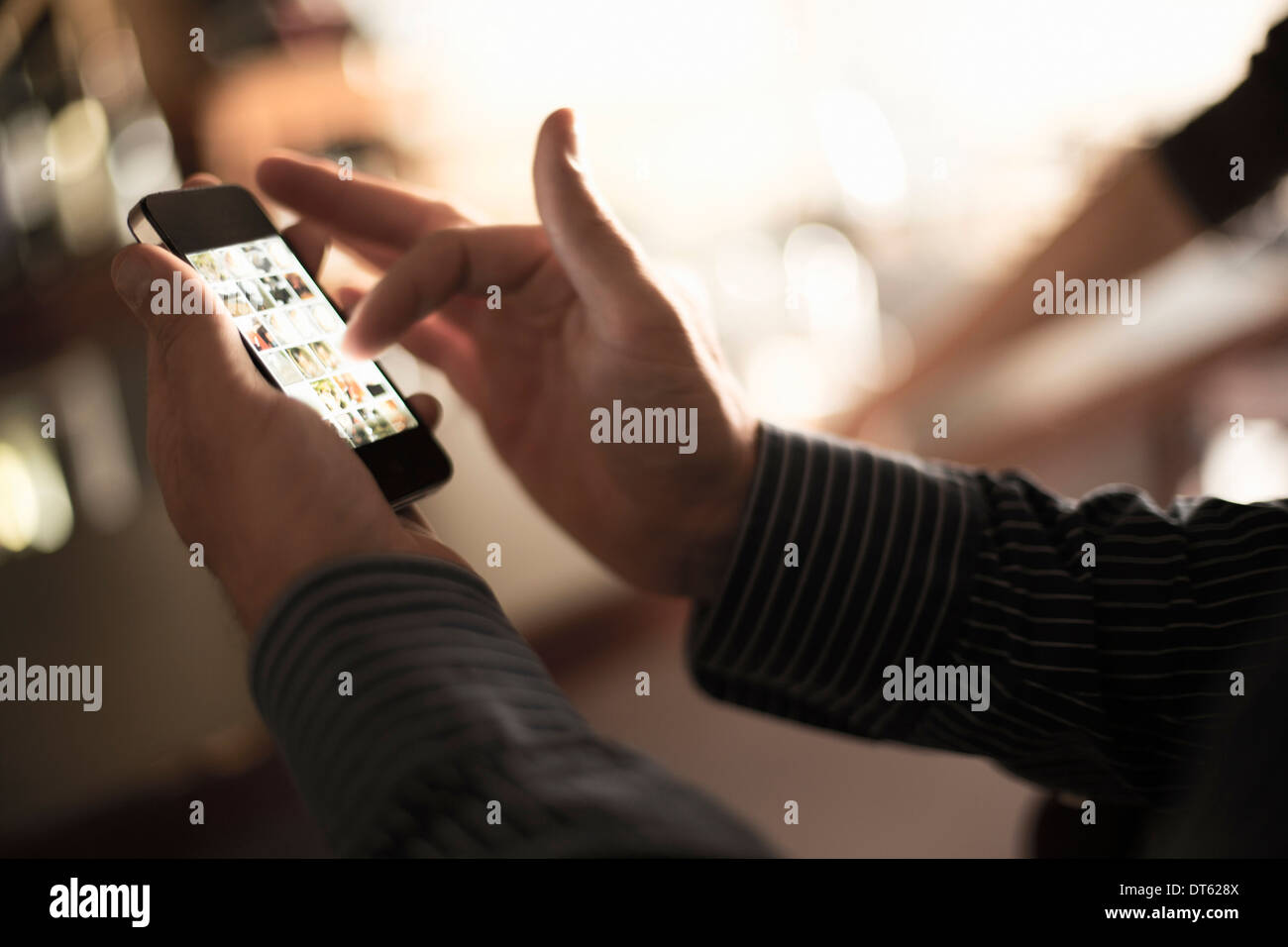 Close up uomo utilizza lo smartphone touchscreen nella wine bar Foto Stock