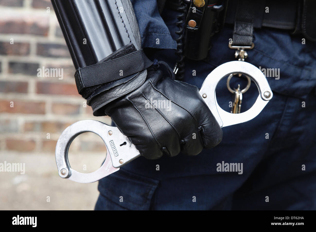 Inghilterra, la società, la legge e l Ordine, dettaglio della polizia legge officer indossare giubbotti antiproiettile e tenendo le manette. Foto Stock