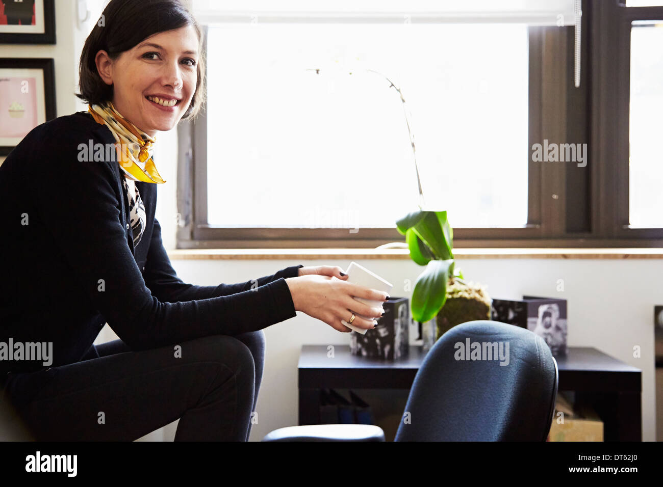 Imprenditrice seduta in ufficio Foto Stock