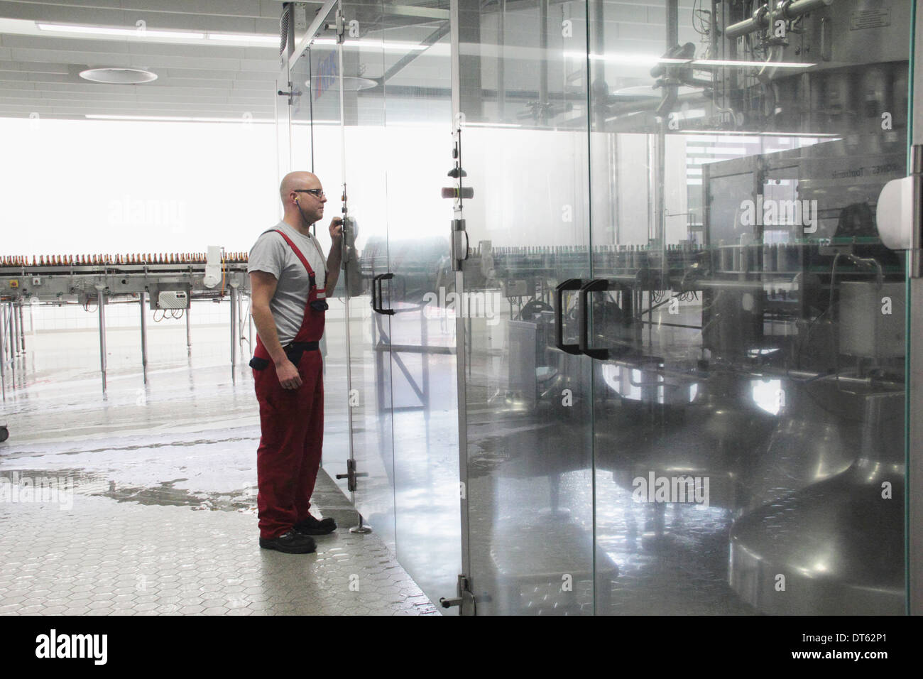 Uomo di apparecchiature di controllo in fabbrica di birra Foto Stock