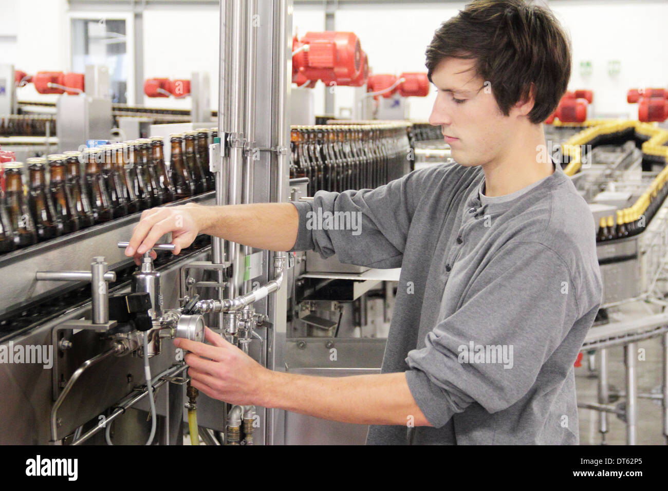 Uomo di controllo apparecchiature industriali in fabbrica di birra Foto Stock