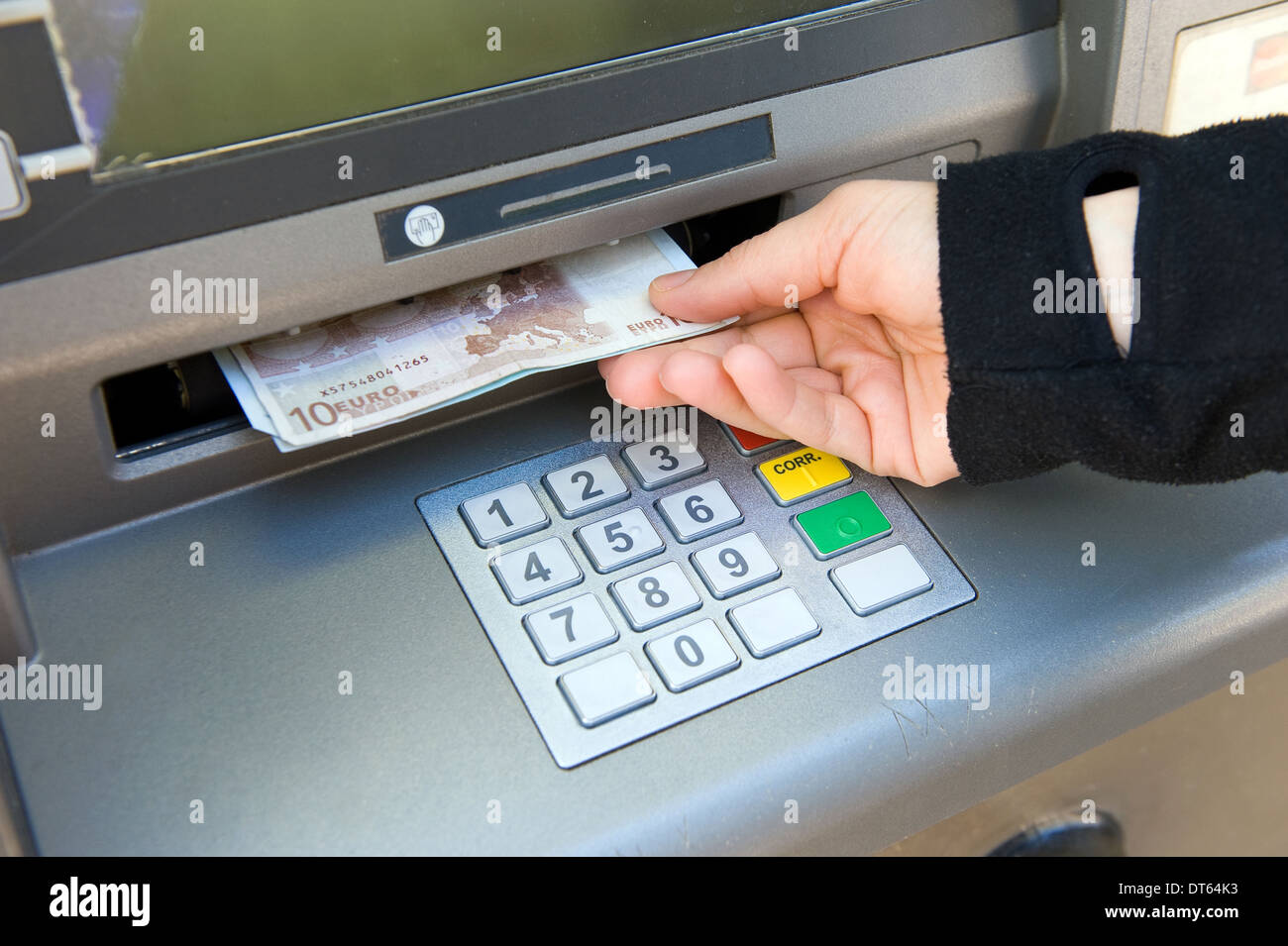 Una donna è il ritiro di denaro contante al di fuori di un bancomat Foto Stock