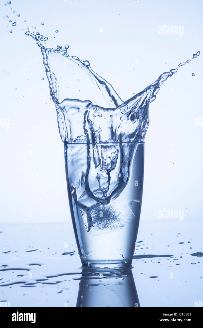 Schizzi di acqua in vetro con gocce Foto Stock