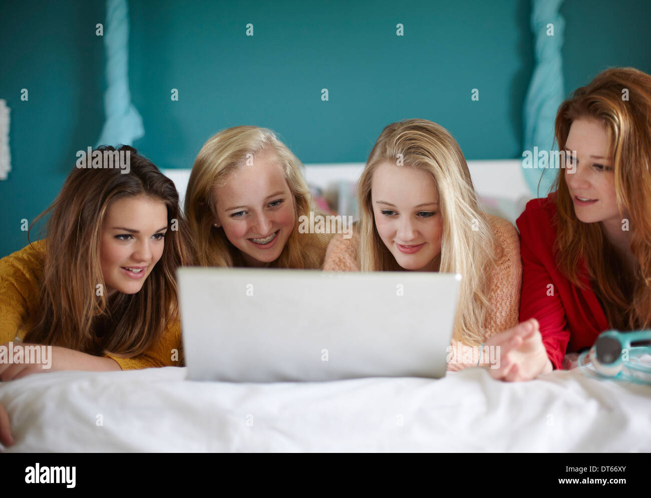 Quattro ragazze adolescenti guardando il computer portatile in camera da letto Foto Stock
