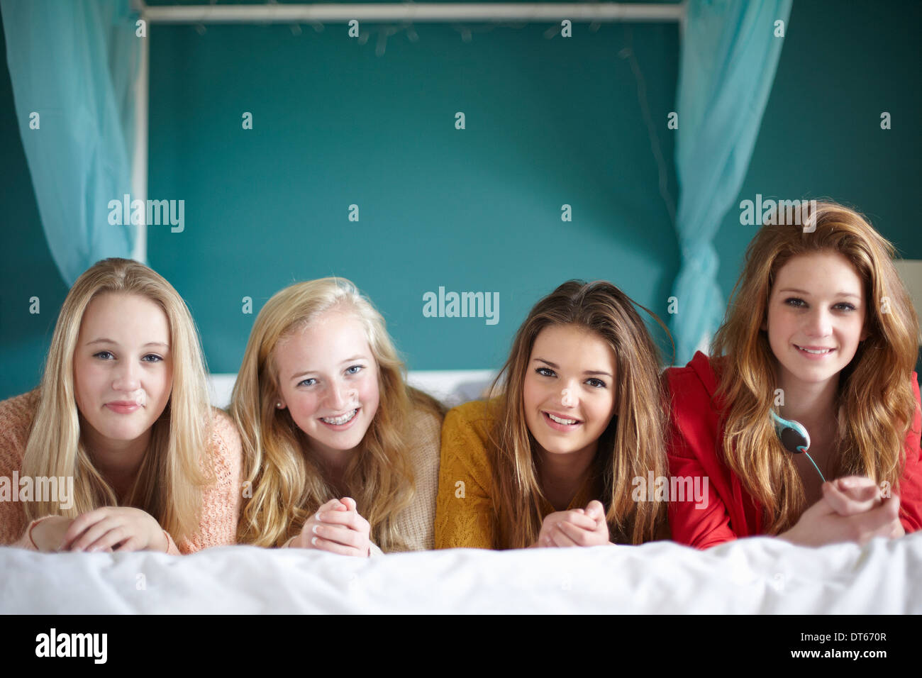 Ritratto di quattro ragazze adolescenti giacente sul letto Foto Stock