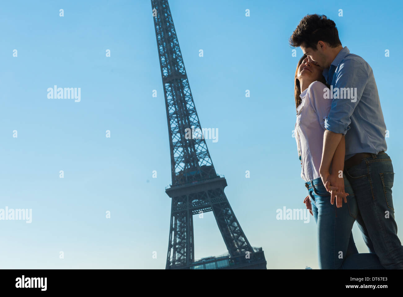 Coppia giovane abbracciando vicino alla Torre Eiffel, Parigi, Francia Foto Stock
