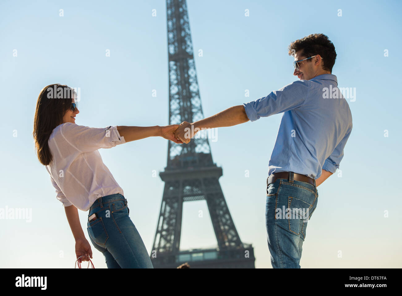 Coppia giovane di fronte alla Torre Eiffel, Parigi, Francia Foto Stock