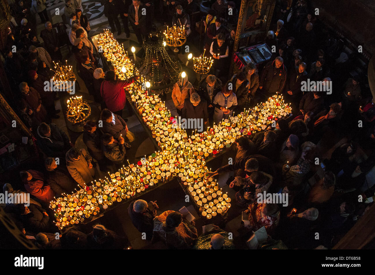 Blagoevgrad, Bulgaria. 10 Febbraio, 2014. Il 10 febbraio, la Chiesa Ortodossa Bulgara celebra il giorno di San Haralambos il martire, che è anche venerato come patrono di tutti gli apicoltori, giardinieri e frutta-coltivatori. I fedeli accendono le candele con vasetti di miele durante una Santa Messa per il 'sanctification di miele'' a ''la Presentazione della Beata Vergine " chiesa cattedrale della città di Blagoevgrad, Bulgaria. Il miele è consacrata e quindi tutto il pane è rivestito con esso. Il resto del miele è mantenuto in casa come un rimedio. Credito: Hristo Vladev/NurPhoto/ZUMAPRESS.com/Alamy Live News Foto Stock