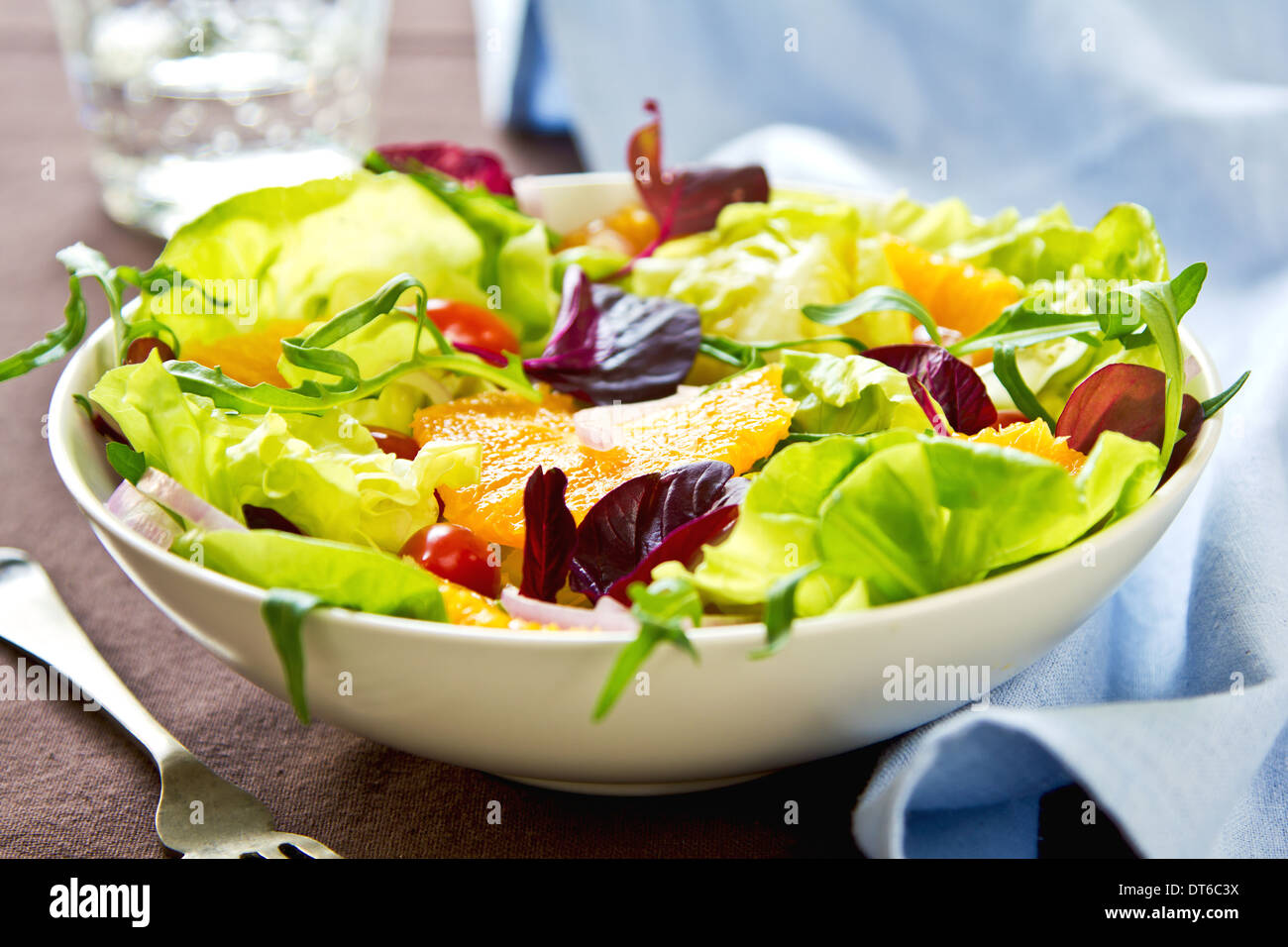 Arancione con rucola e melograno insalata in una ciotola Foto Stock