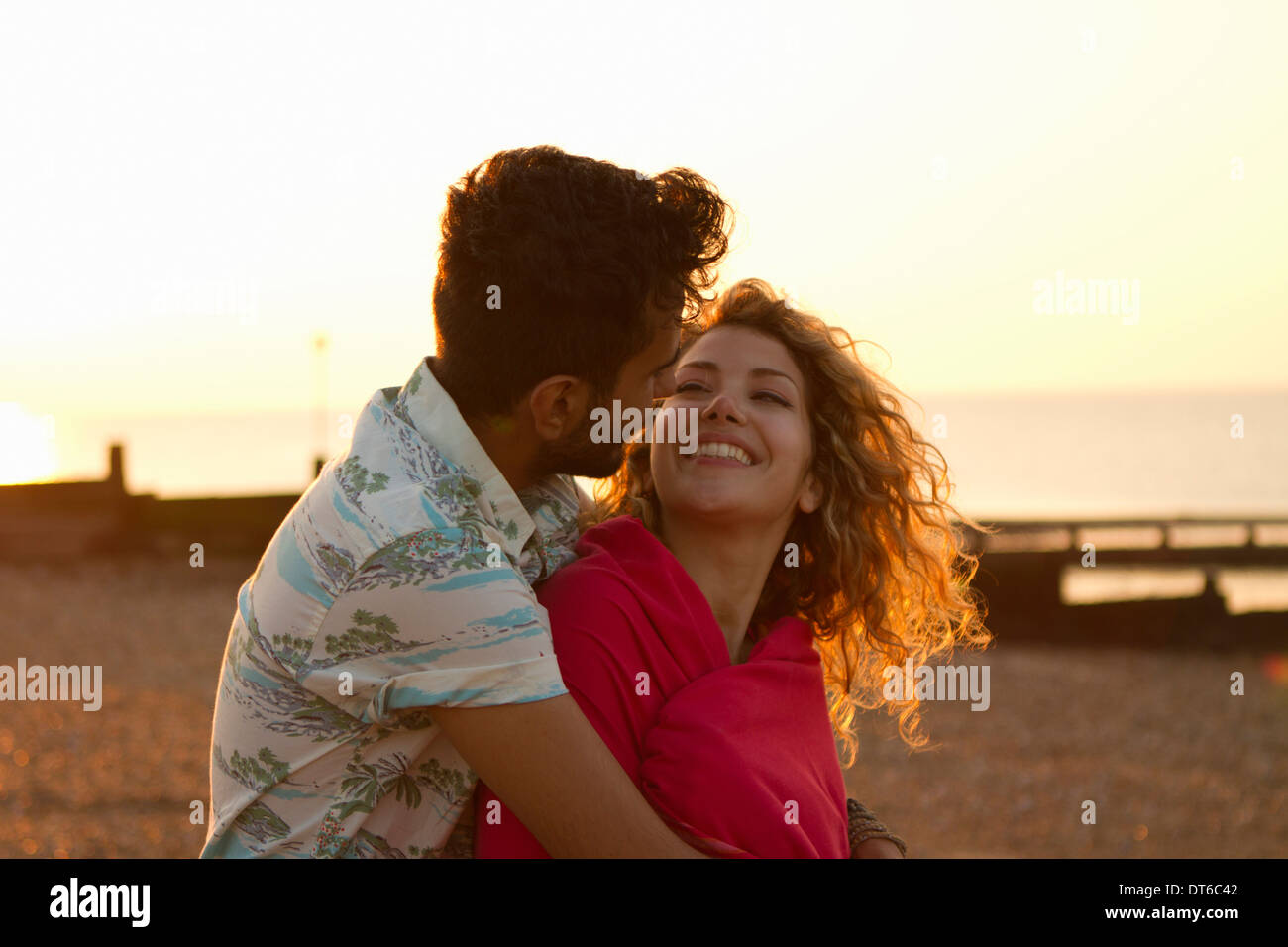 Coppia giovane avvolto in asciugamano sulla spiaggia Foto Stock