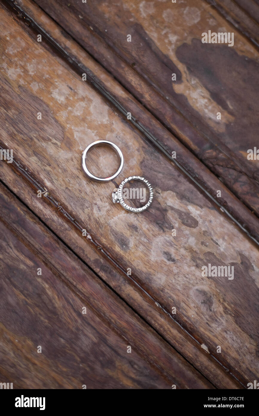 Platino anelli di nozze . Due anelli su un usurato sfregati colorate in superficie in legno. Foto Stock
