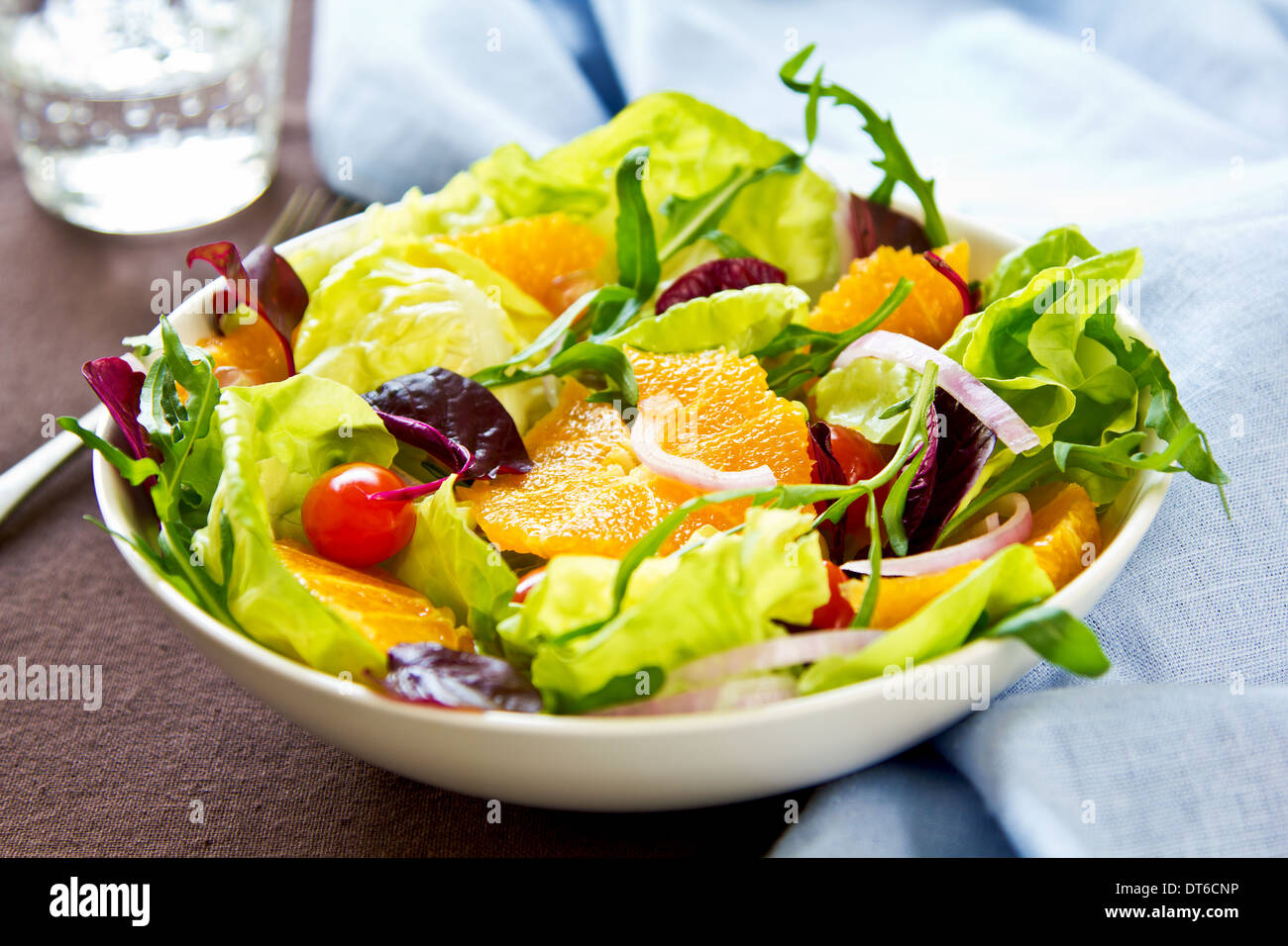 Arancione con rucola e melograno insalata in una ciotola Foto Stock