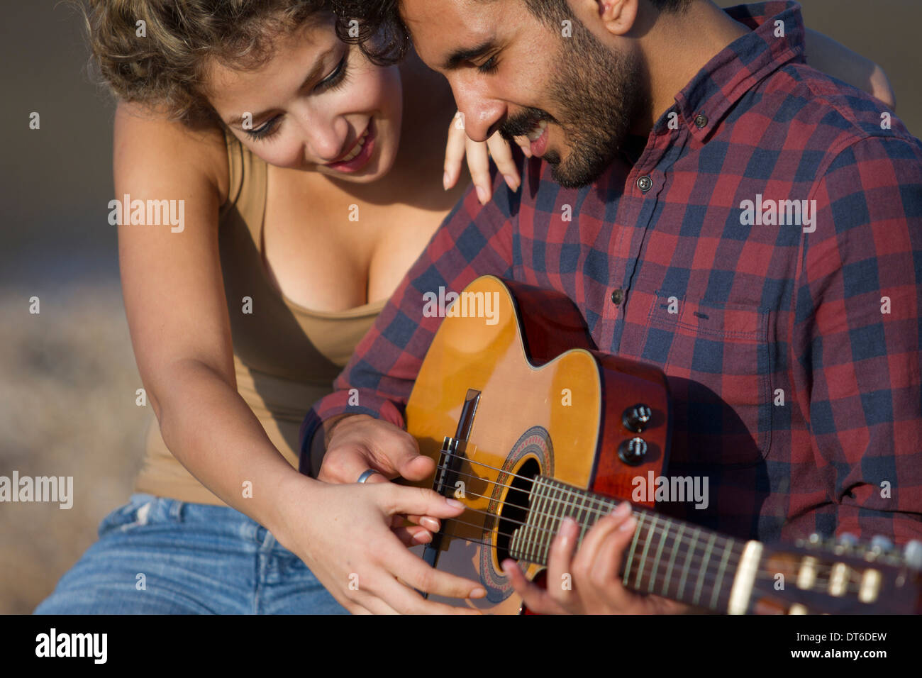 Coppia giovane, uomo a suonare la chitarra Foto Stock