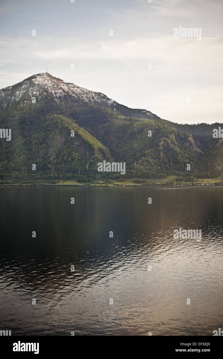 Un picco di montagna che domina un lago, creando una riflessione sulla calma della superficie dell'acqua. Foto Stock