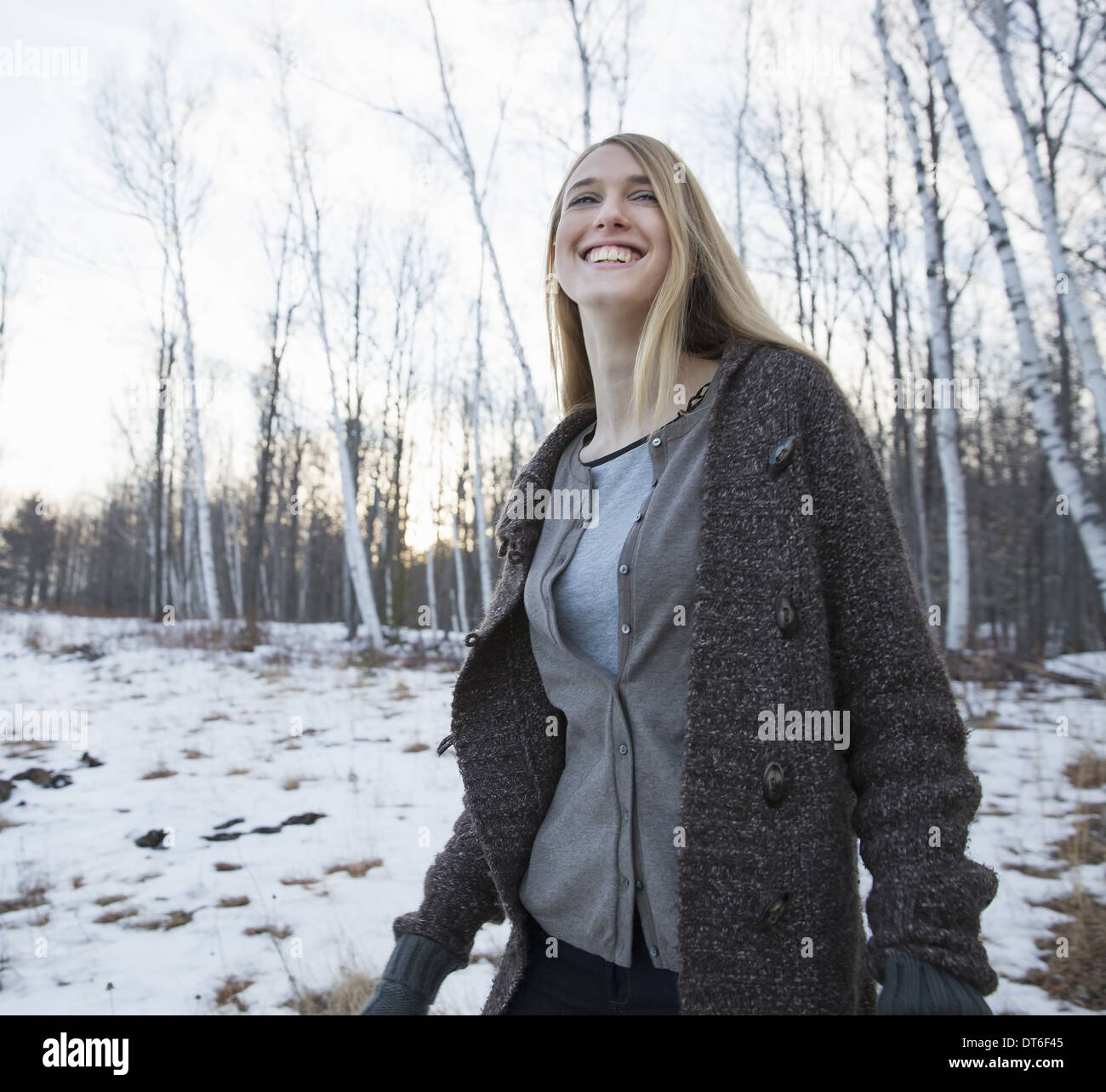 Una giovane donna con capelli lunghi biondi all'aperto su un giorno d'inverno. Foto Stock