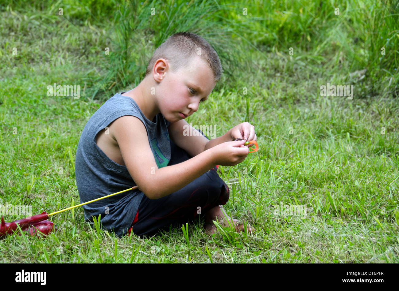 Ragazzo giovane maschio adesca il bambino un amo da pesca canna da pesca Foto Stock