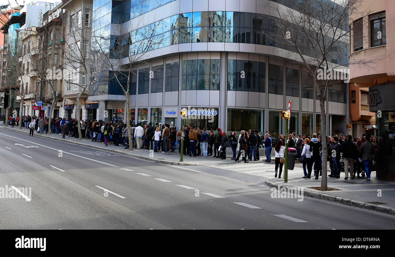 Le persone attendono in coda il loro turno di applicare per un'offerta di lavoro nell'isola di Mallorca, Spagna Foto Stock
