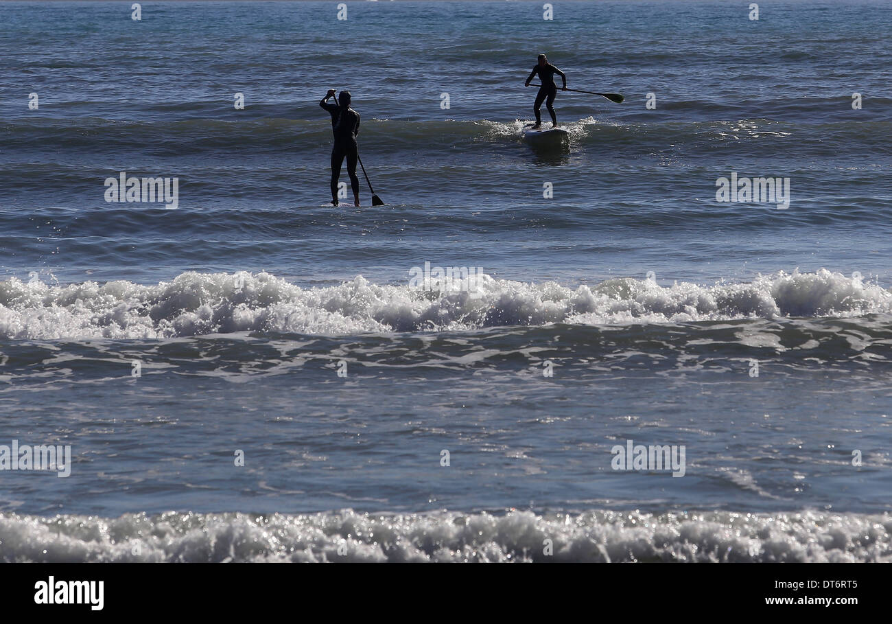 La gente pratica SUP stand up paddle, in una spiaggia dell'isola di Mallorca, Spagna Foto Stock