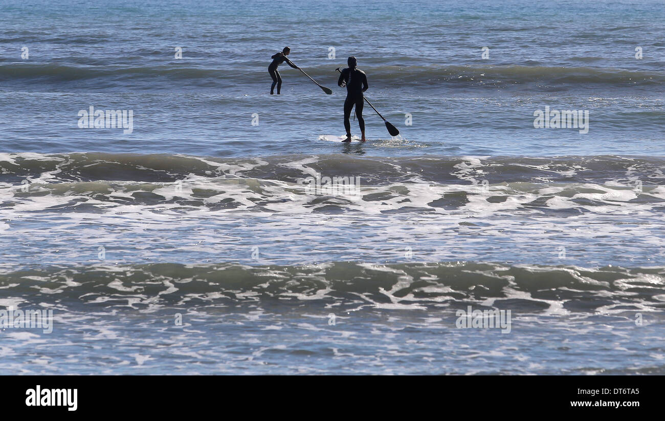La gente pratica SUP stand up paddle, in una spiaggia dell'isola di Mallorca, Spagna Foto Stock