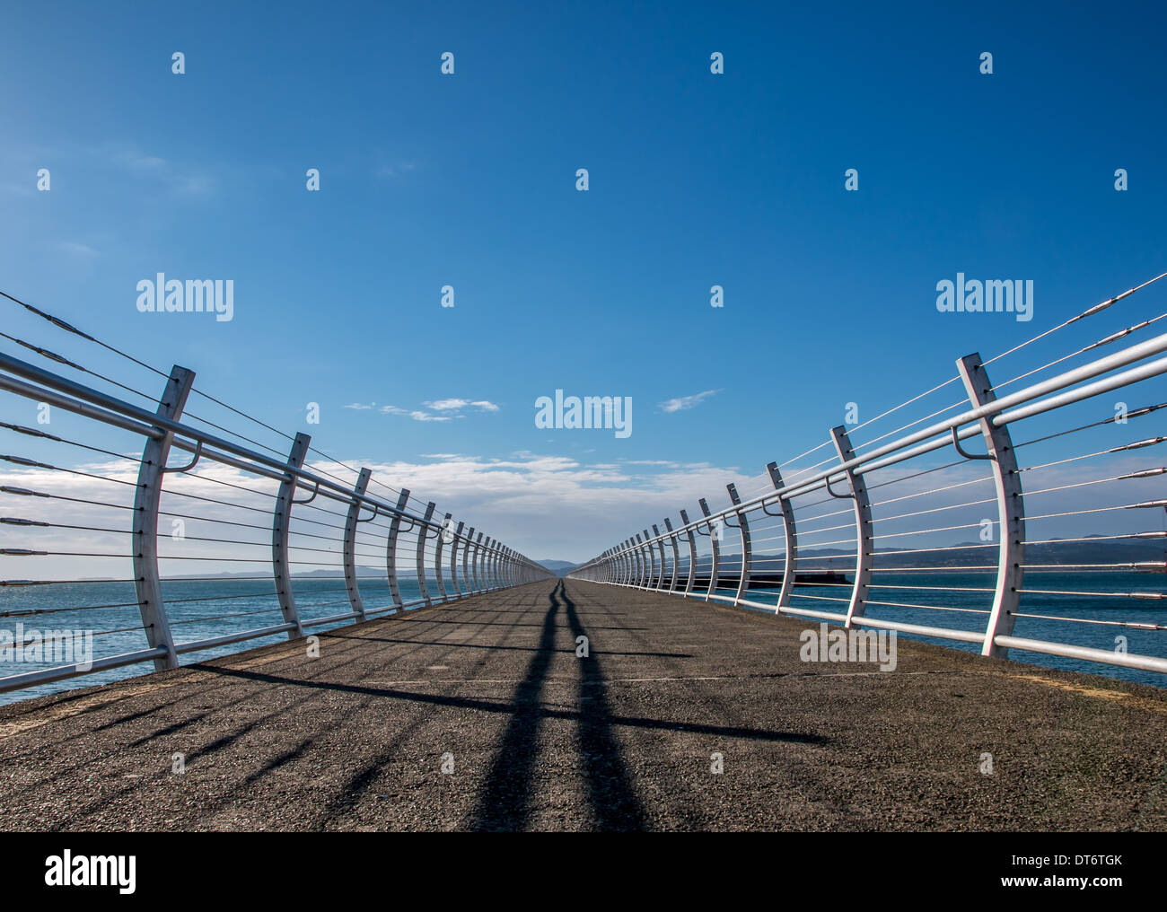 Corrimano e ombre su una struttura di frangionde retrocedere nella distanza. Foto Stock