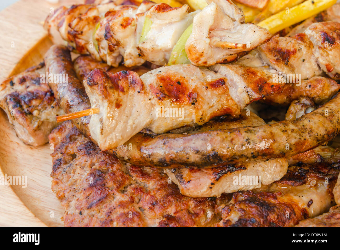 Gli spiedini e grigliate di carne di maiale, salsicce e braciole con patate Foto Stock