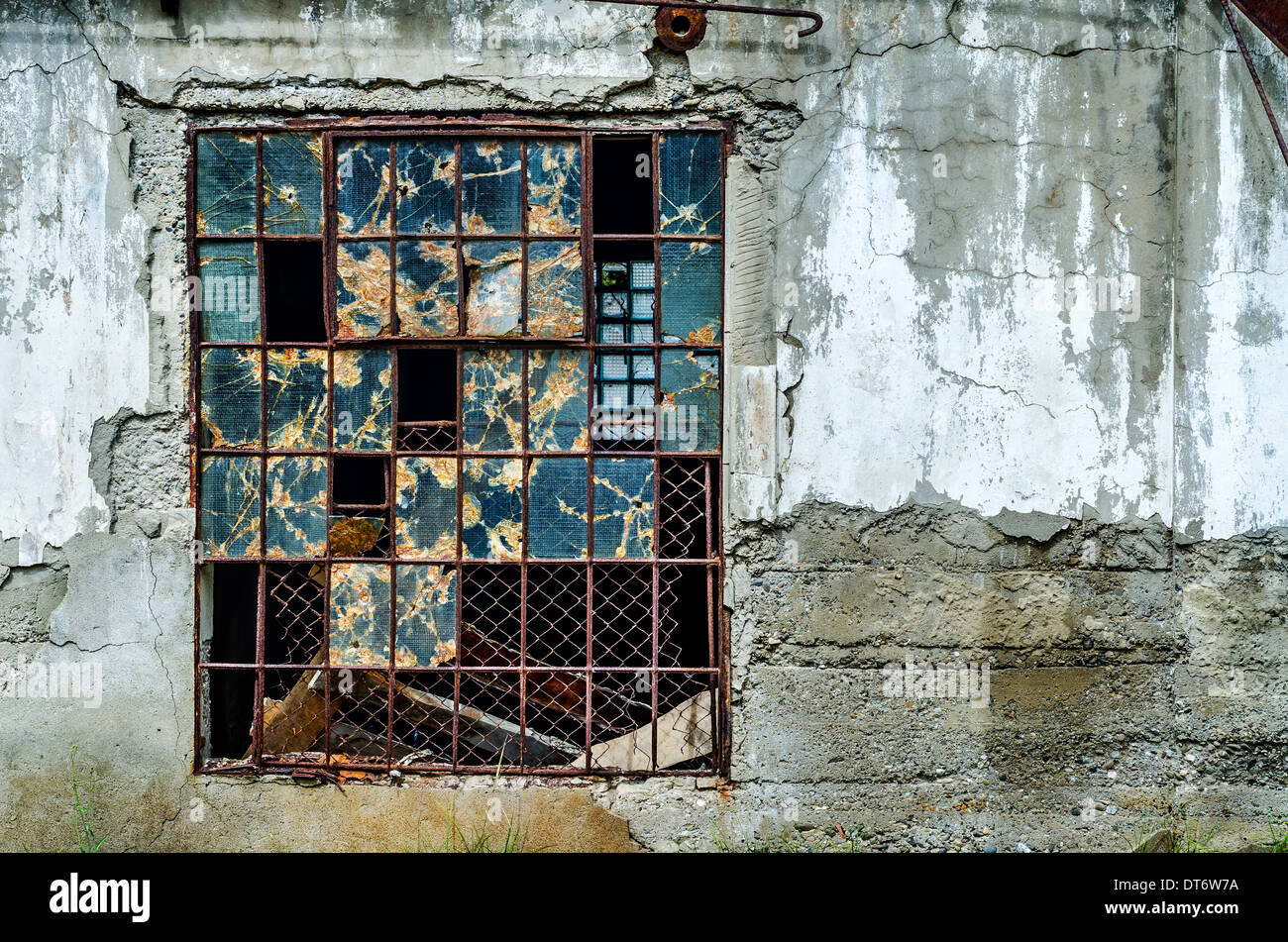 Vecchia finestra rotta in grigio muro di cemento Foto Stock