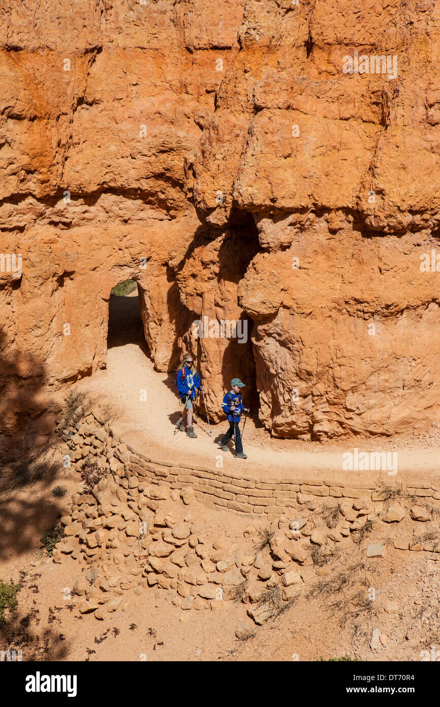 Gli escursionisti passano attraverso un tunnel lungo la Queens Garden Trail nel Parco Nazionale di Bryce Canyon, Utah. Foto Stock