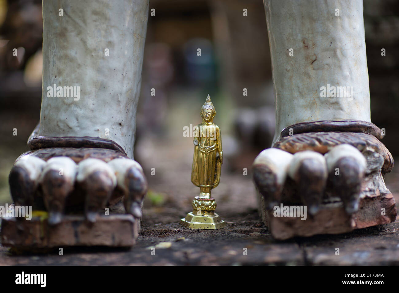 Oro figura alla base di un Leone asiatico statua Foto Stock
