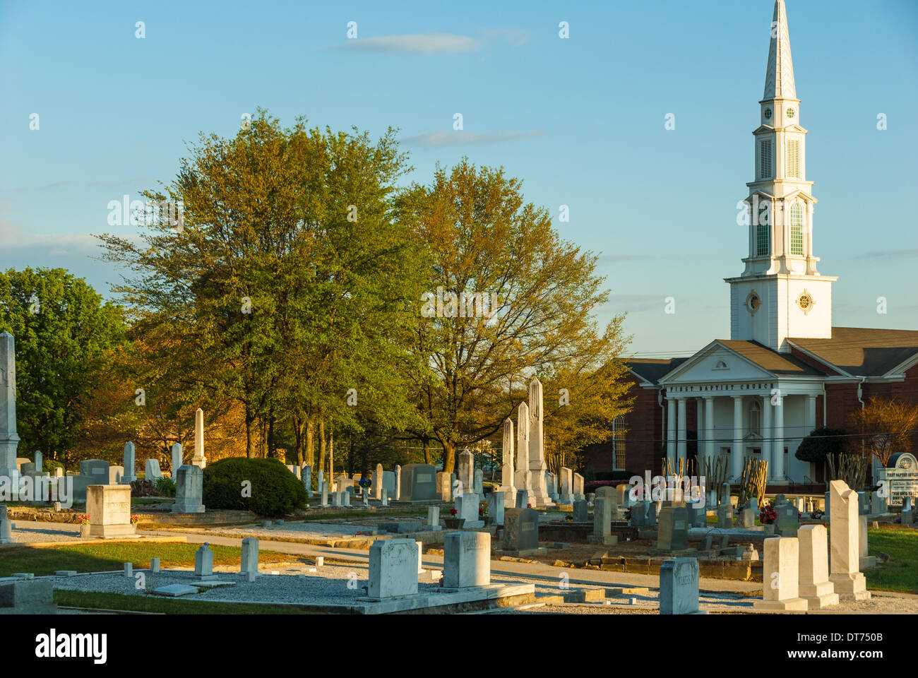 Un sole che tramonta mette in risalto i marcatori e i monoliti del cimitero storico di Snellville e della prima chiesa battista di Snellville, Georgia. (USA) Foto Stock