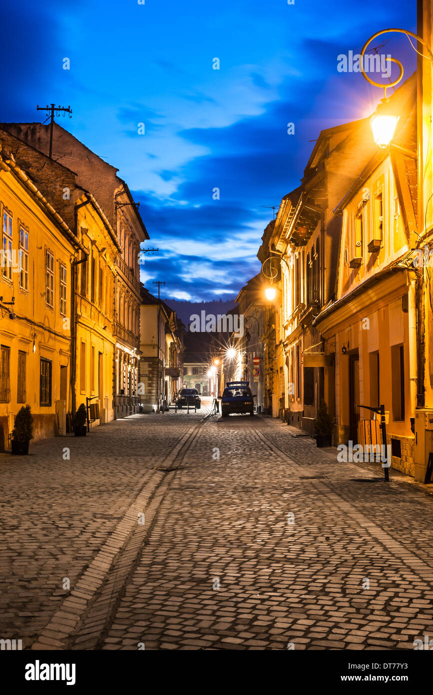 Brasov, in Transilvania. Scena notturna del borgo medievale di strada asfaltata nel centro della citta'. Punto di riferimento sassone in Romania. Foto Stock